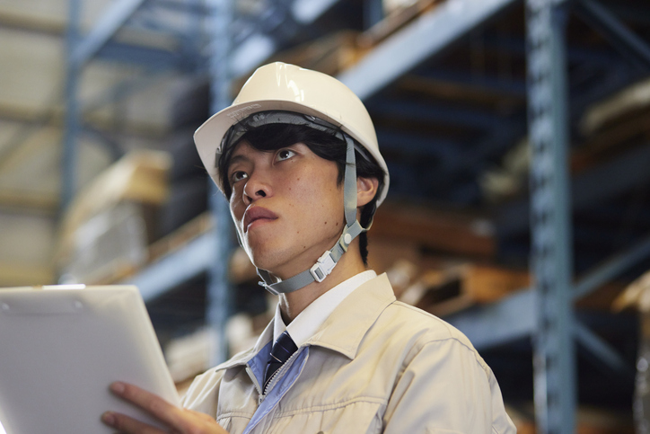 A man wearing work clothes inspecting a factory A man wearing work clothes inspecting a factory