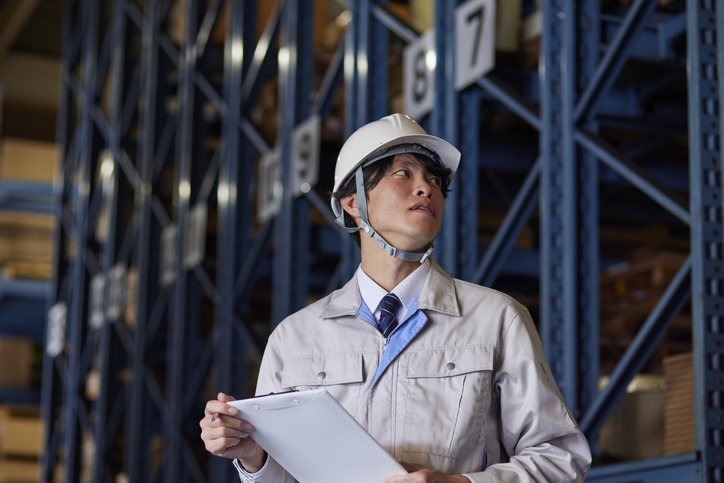 A man wearing work clothes inspecting a factory A man wearing work clothes inspecting a factory